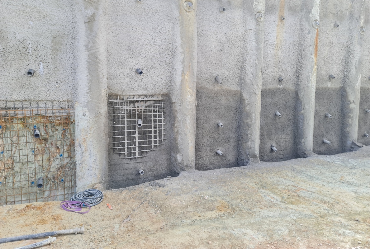 Layer by layer, the areas of quartzite rock between the bored piles are exposed. After lining with steel mesh, shotcrete is applied. The amount of shotcrete used is kept to a minimum.