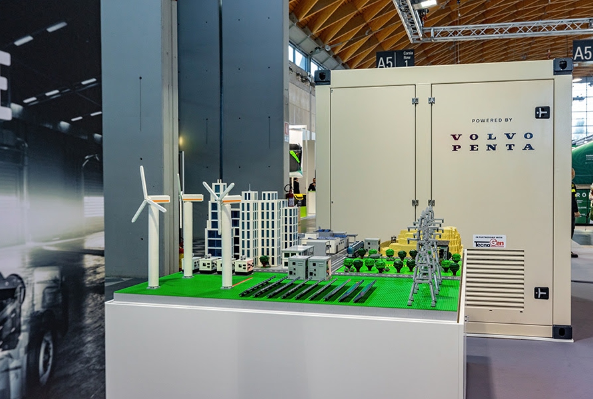 TecnoGen’s BESS for heavy-duty vehicle charging sitting next to a model showcasing BESS potential in different parts of society.