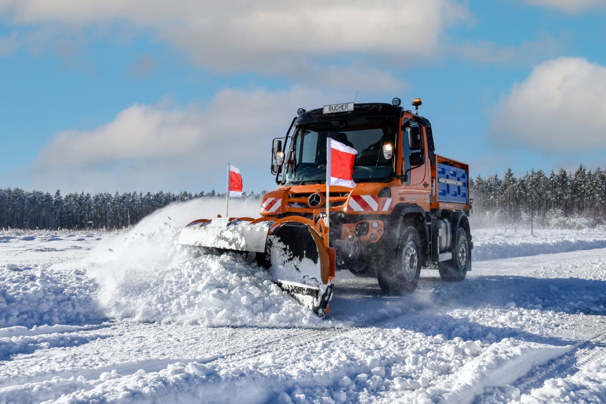 Unimog implement carrier with winter service equipment by Bucher Municipal