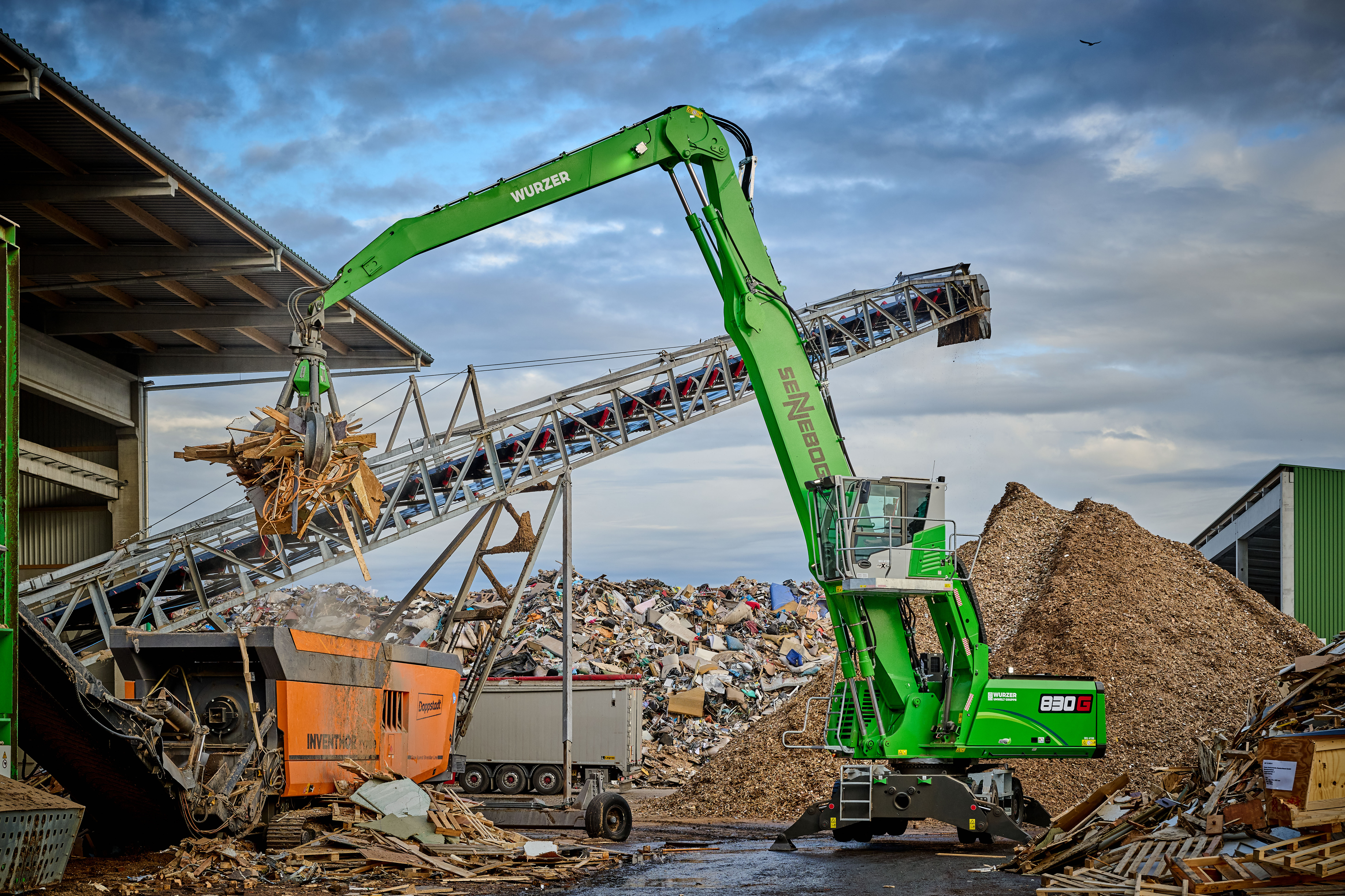 The green all-rounder feeds waste wood to a shredder at the Wurzer Umwelt site in Eitting.