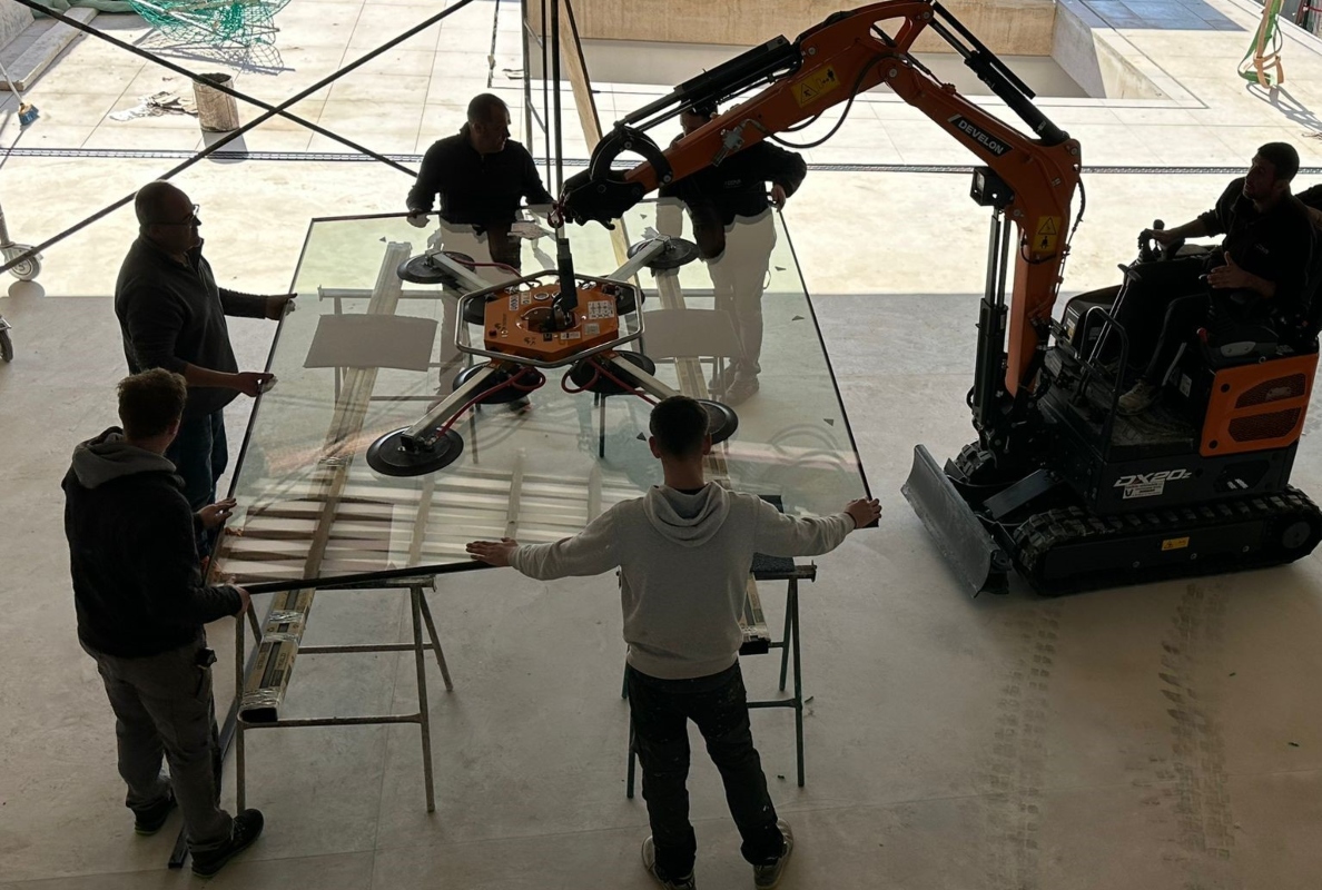 Develon Mini-Excavator Used to Install Panes of Glass in Home