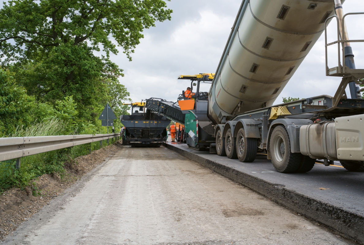 A Vögele MT 3000-3i PowerFeeder transferring BSM cold mix to the SUPER 1900-3i paver.