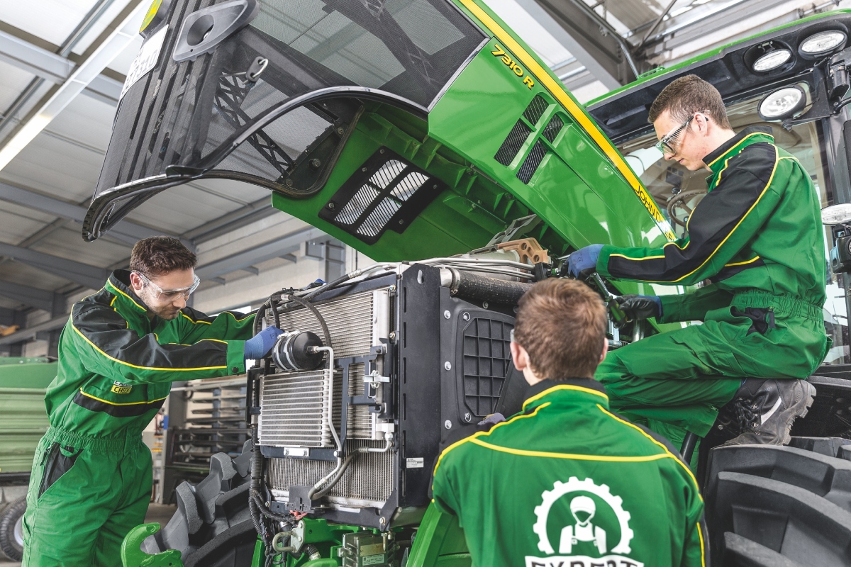 Apprentices working on a John Deere ag tractor