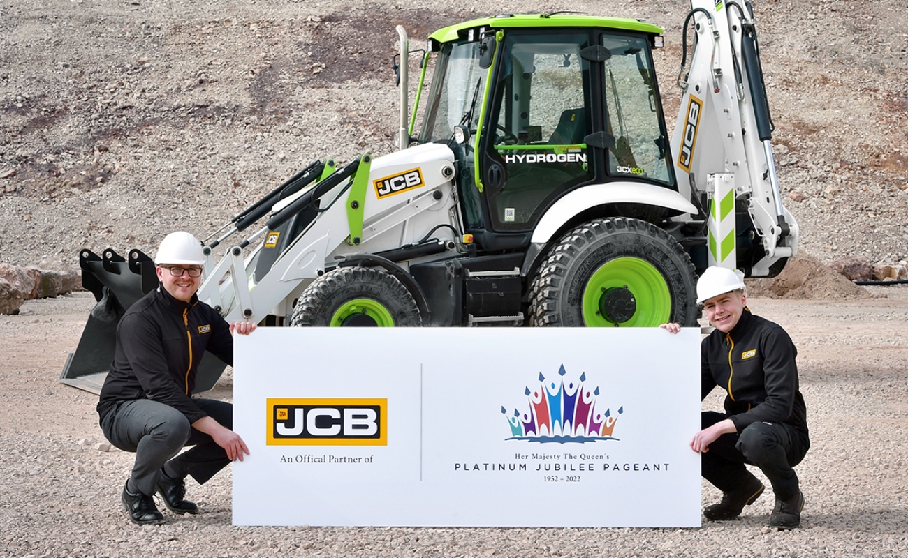 JCB Engineering Graduate James Ownsworth (left) and Engineering Degree Apprentice Jed Brandreth pictured with JCB’s hydrogen powered backhoe loader which will take part in the Platinum Jubilee Pageant next month.