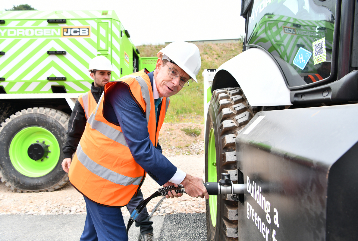 West Midlands Mayor Andy Street refuels a JCB backhoe loader with hydrogen from the new JCB refueller during a visit to JCB