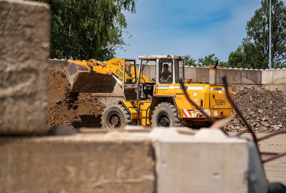 An older-generation L 521 wheel loader loads various types of mineral waste.