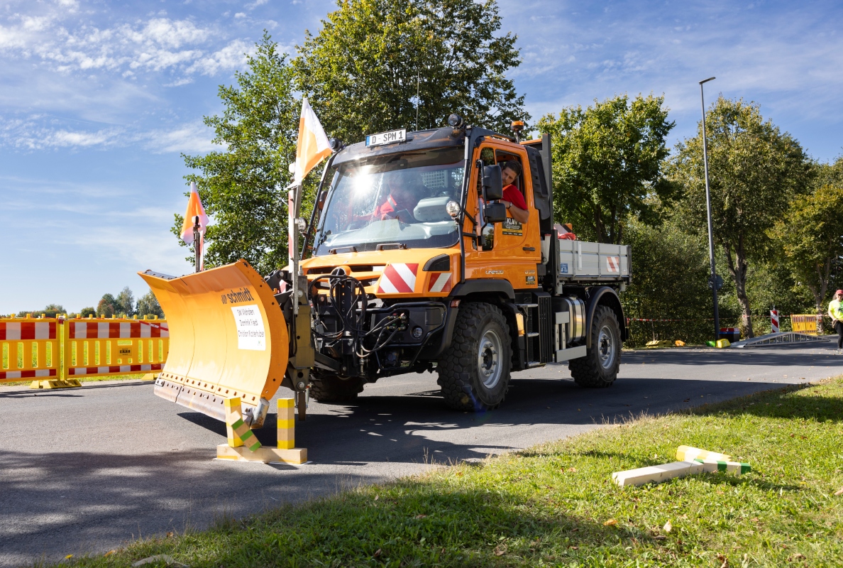 On the course of the German snow plow championship, a Unimog maneuvers precisely past the obstacles