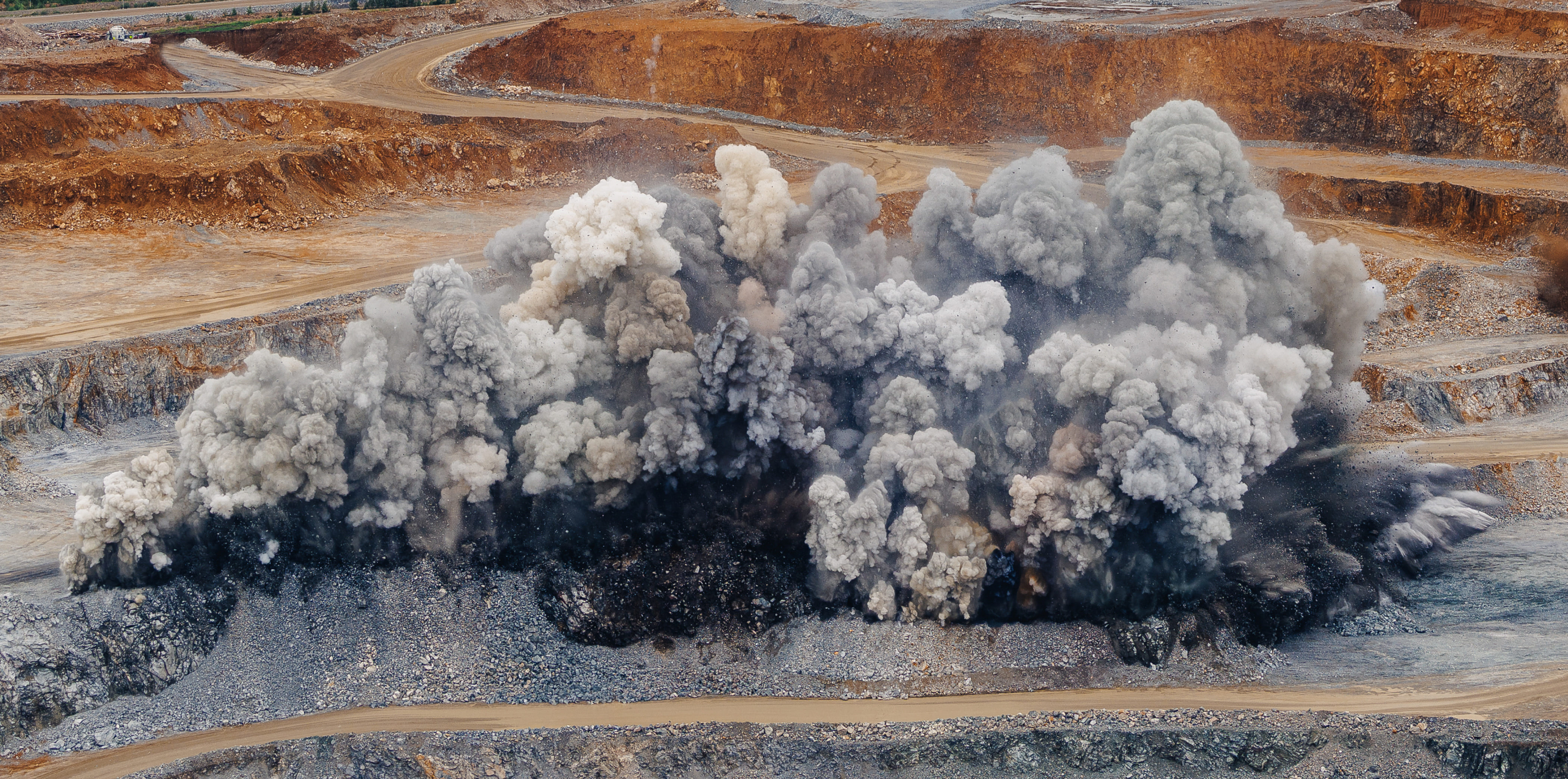 Aerial view of a large aggregates quarry, showing heavy machinery, diggers, and storage warehouses.