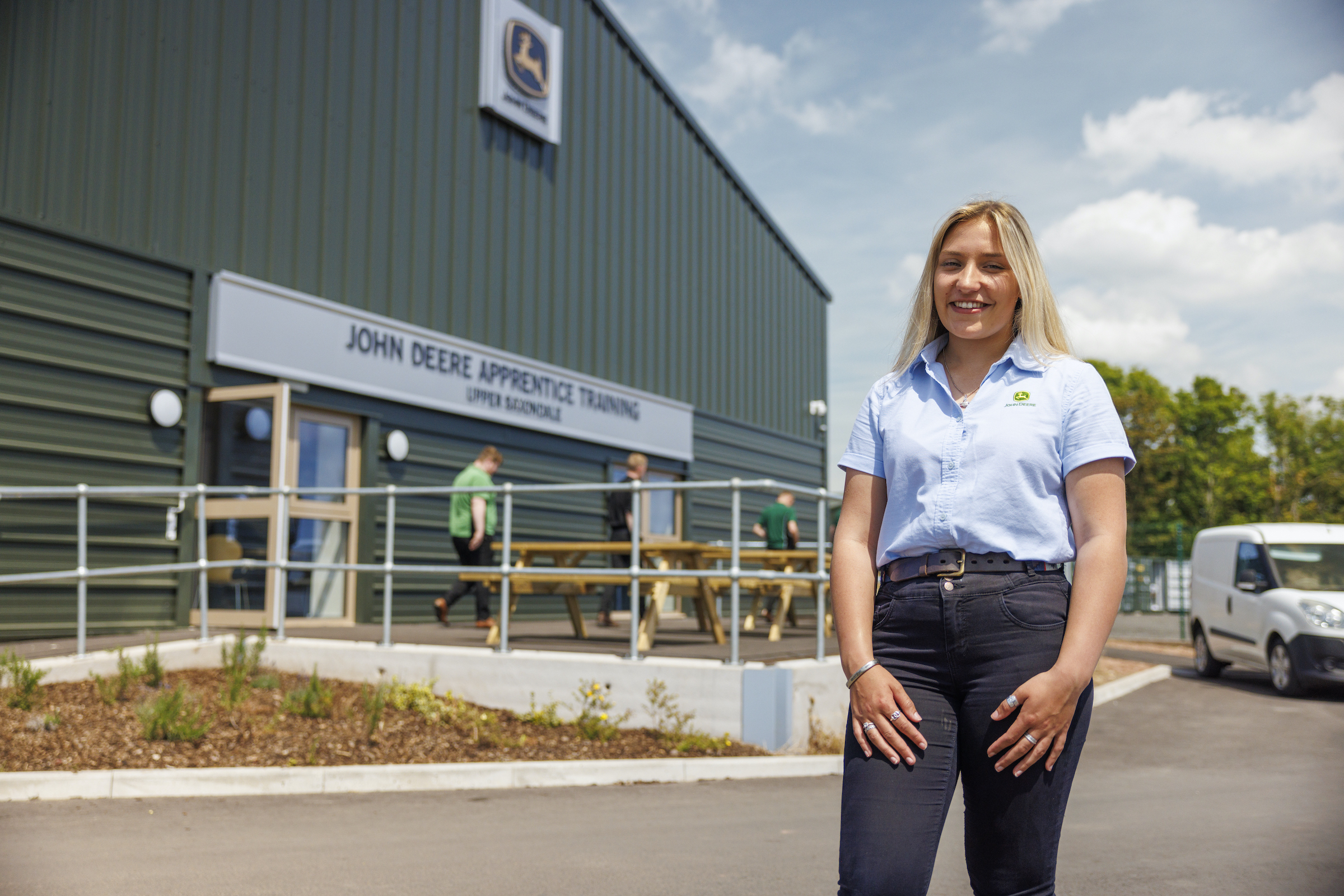 Honor Miles, an Apprentice Technician, stands in front of the new John Deere Training Centre.