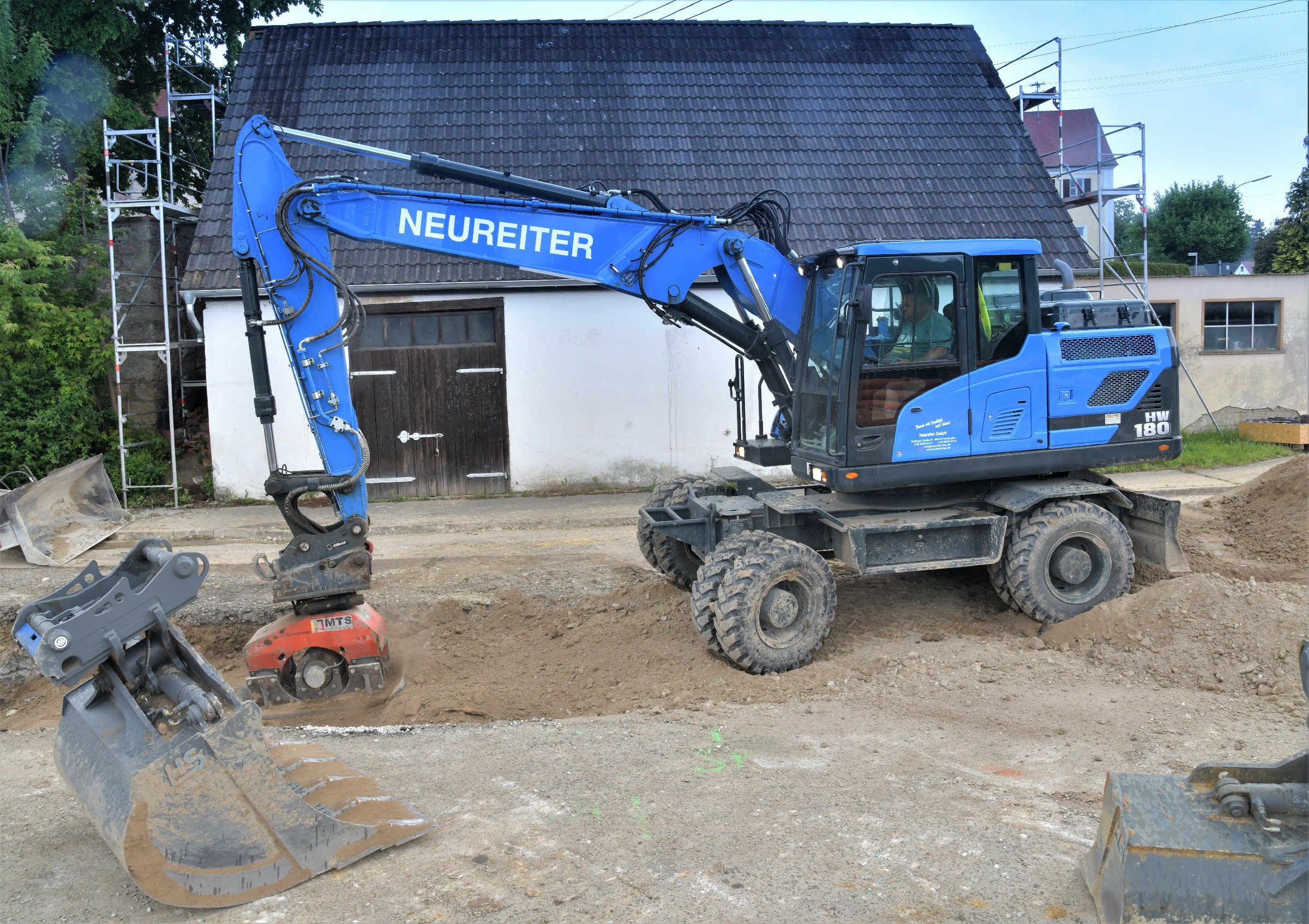 The Hyundai HW180 wheeled excavator at work replacing a 2,500-metre-long main  sewerage line in Minderoffingen. Compacting a freshly filled trench with a vibrator  attachment.