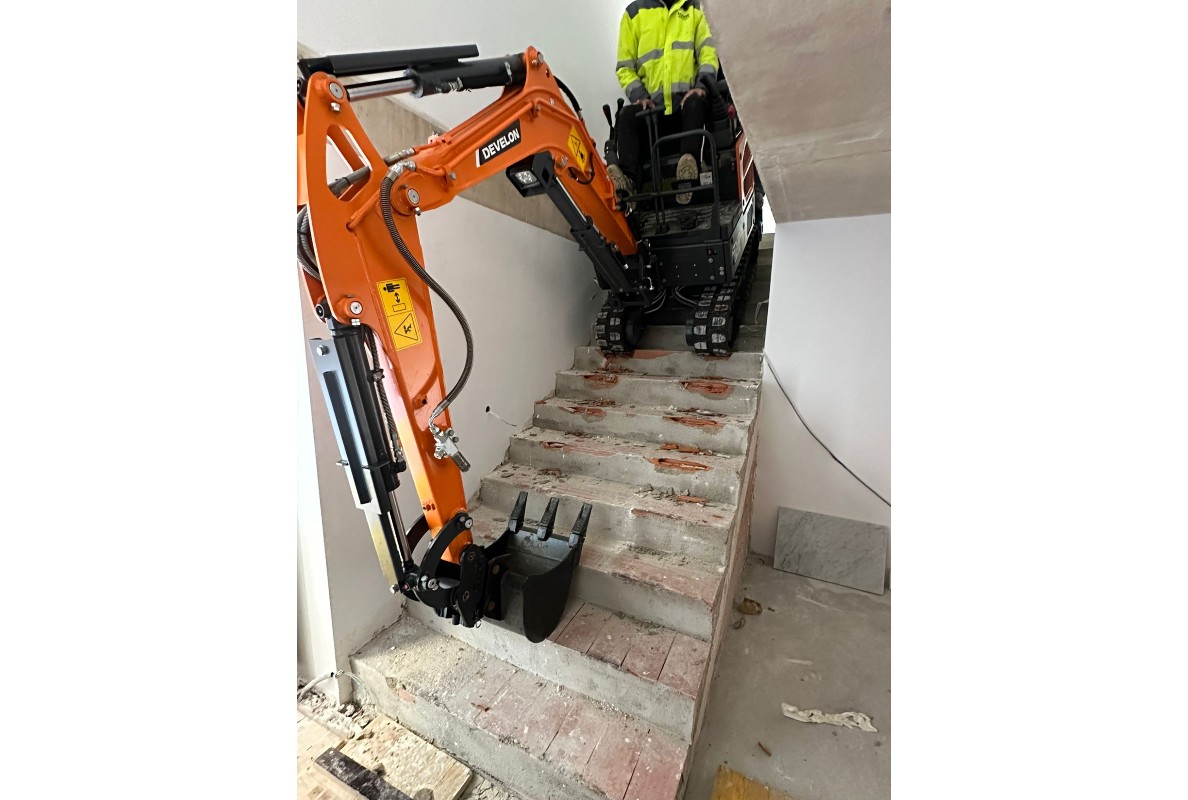 Develon Mini-Excavator Used to Install Panes of Glass in Home
