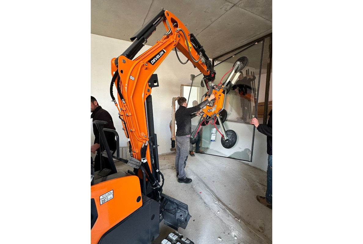 Develon Mini-Excavator Used to Install Panes of Glass in Home