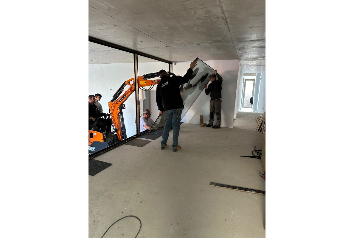 Develon Mini-Excavator Used to Install Panes of Glass in Home