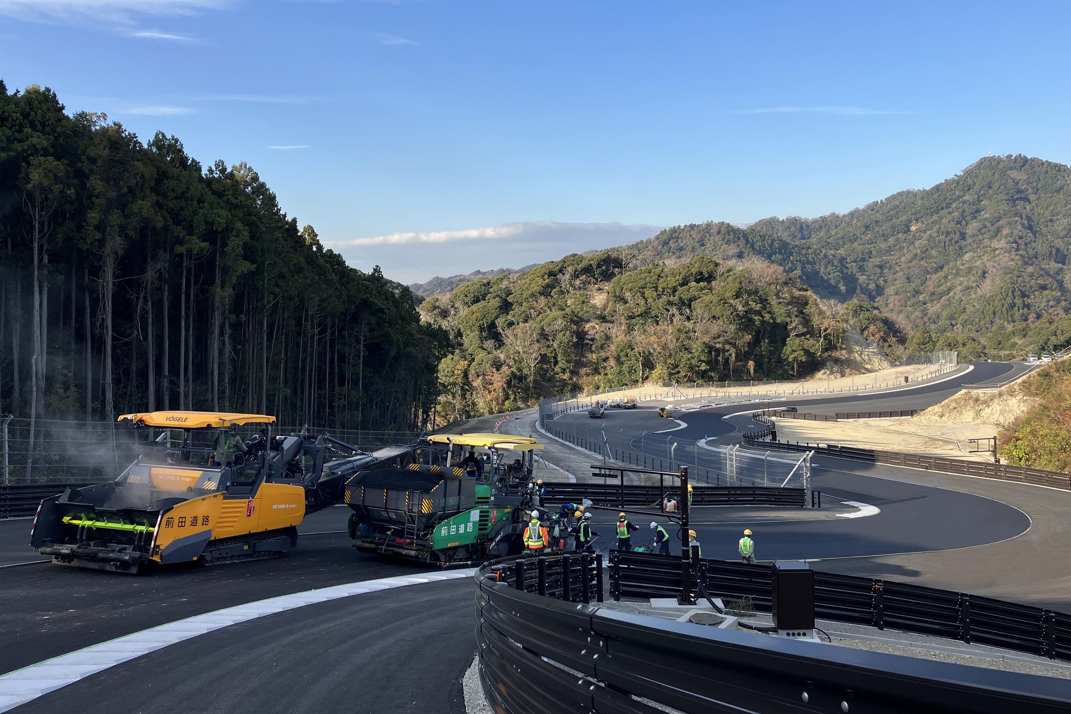 Unique race track near Tokyo: three pavers and a material feeder from Vögele completed the four-layer paving operation in this undulating landscape.