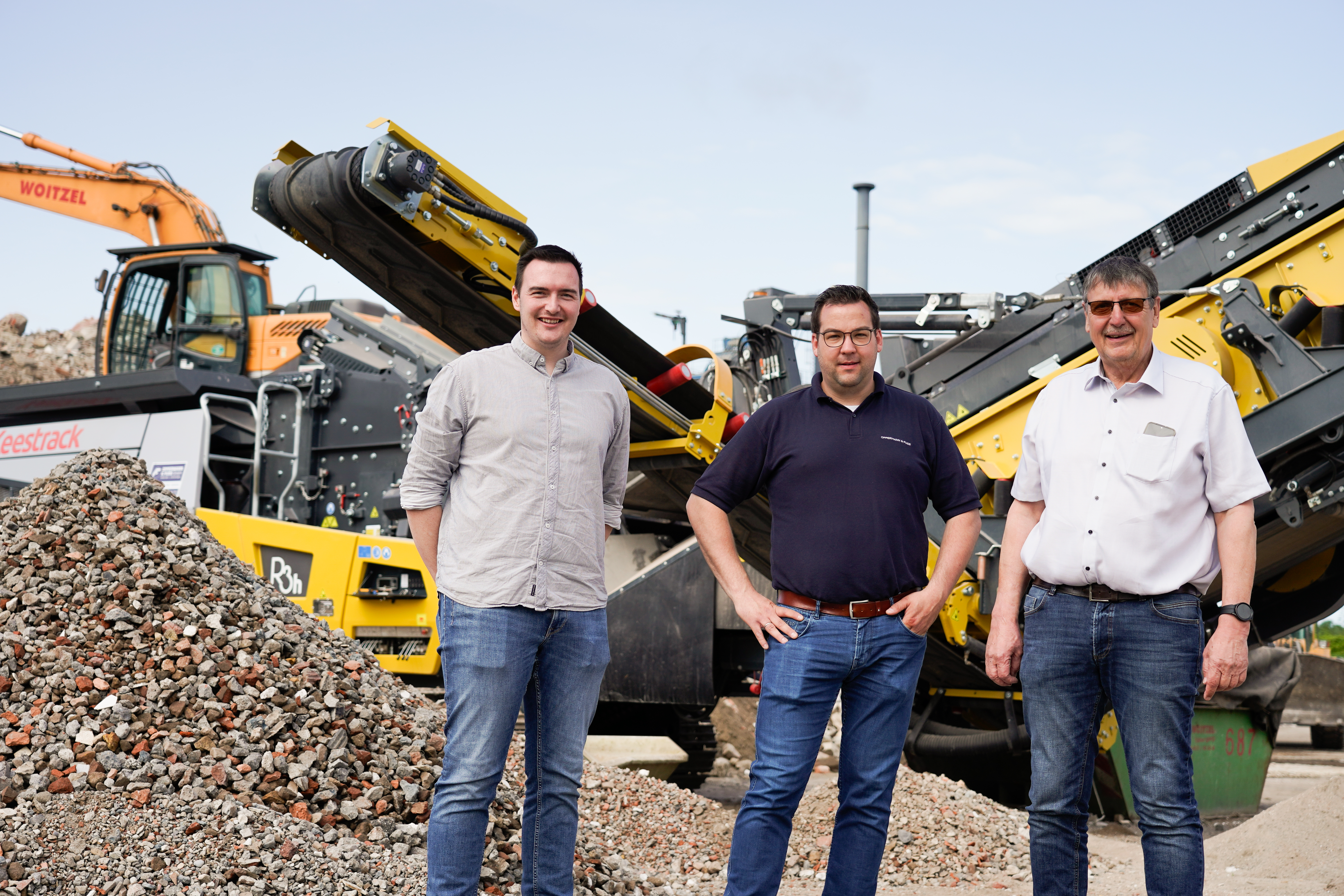 Jannik Woitzel, Julian Pollmeyer and Uwe Woitzel in front of the R3 impact crusher. (LTR)