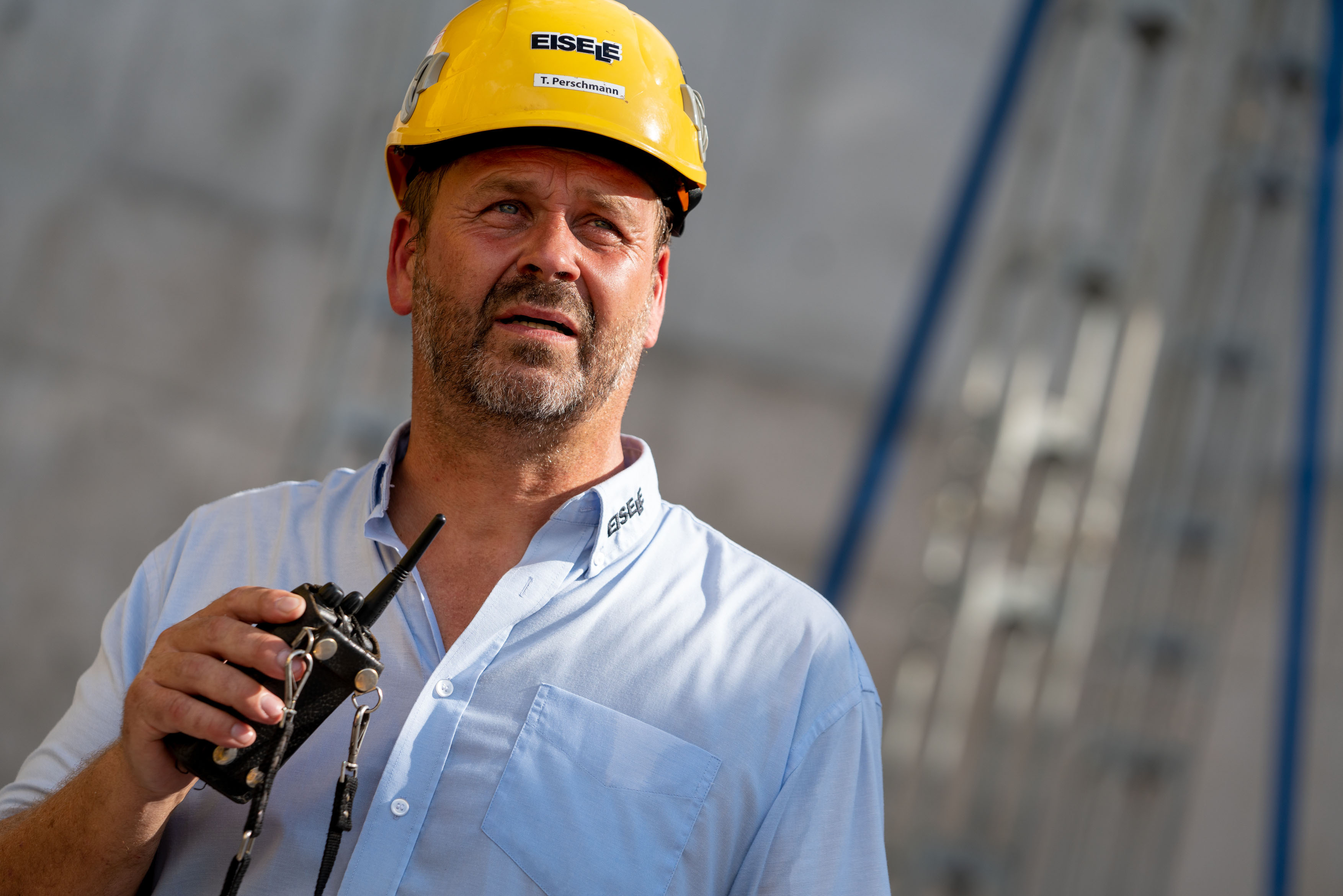Well planned: Tino Perschmann focuses intently as he issues instructions to his crane driver over the radio. As a member of  Eisele's external technical team, he took care of the preparation for this exciting assignment in Wiesbaden.