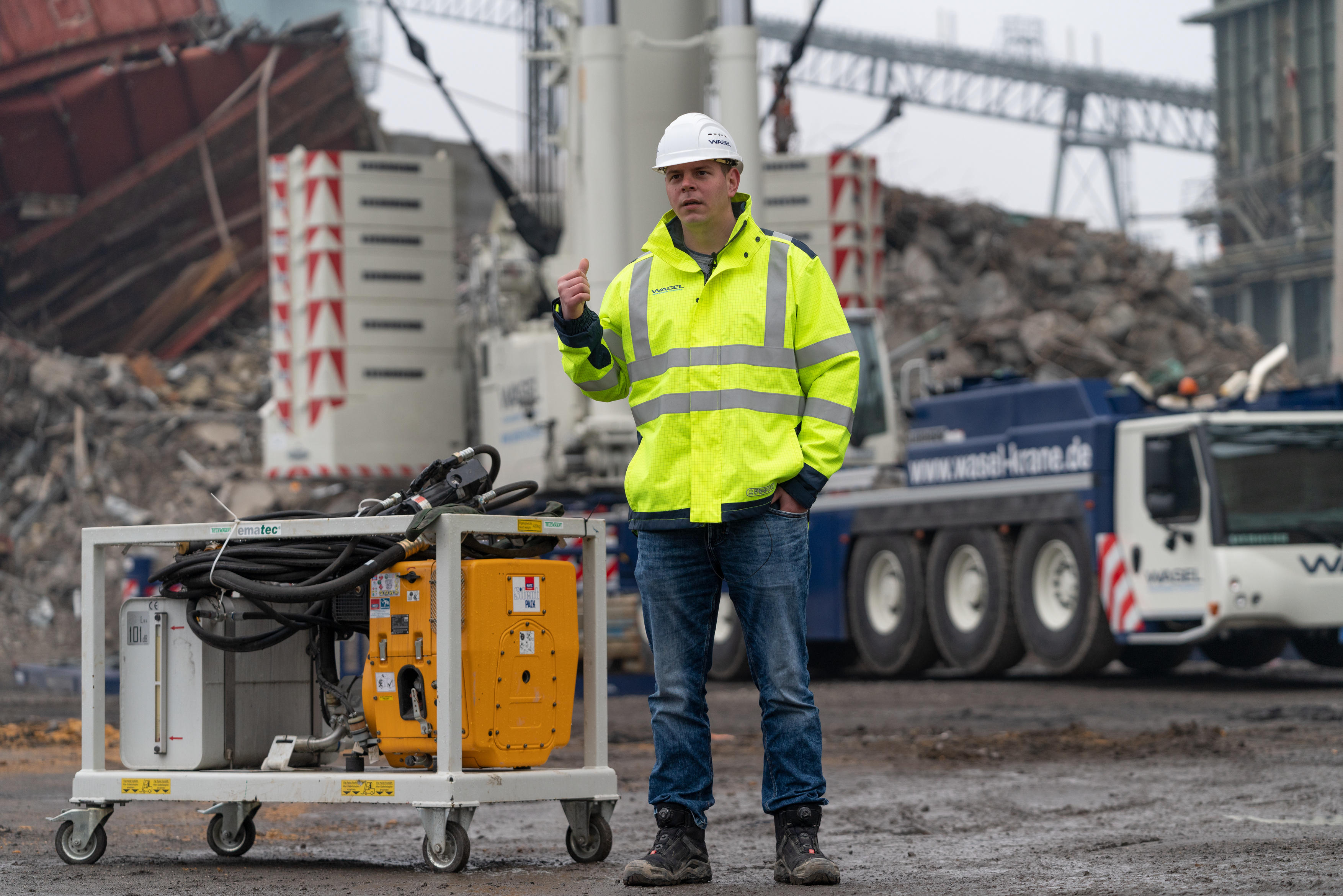 In case of emergency – Project Manager Maurizio Ising explains how the hydraulic unit works to enable the safety cage on the crane’s hook to be lowered at any time if the crane’s engine suffers a failure. <br> Image source: Liebherr-Werk Ehingen GmbH