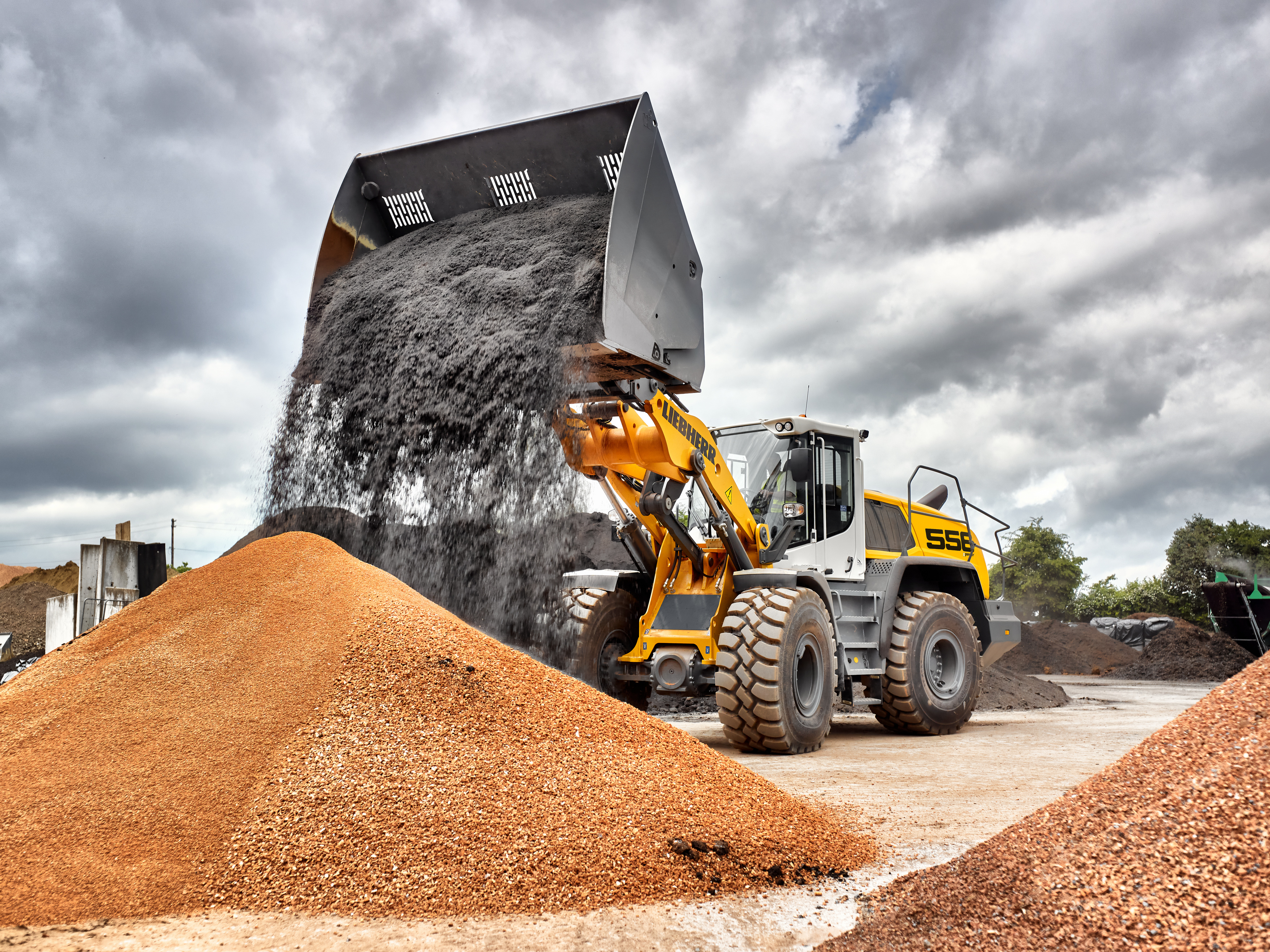 An L 556 XPower® with industrial kinematics and high dump bucket loading soil and substrate.