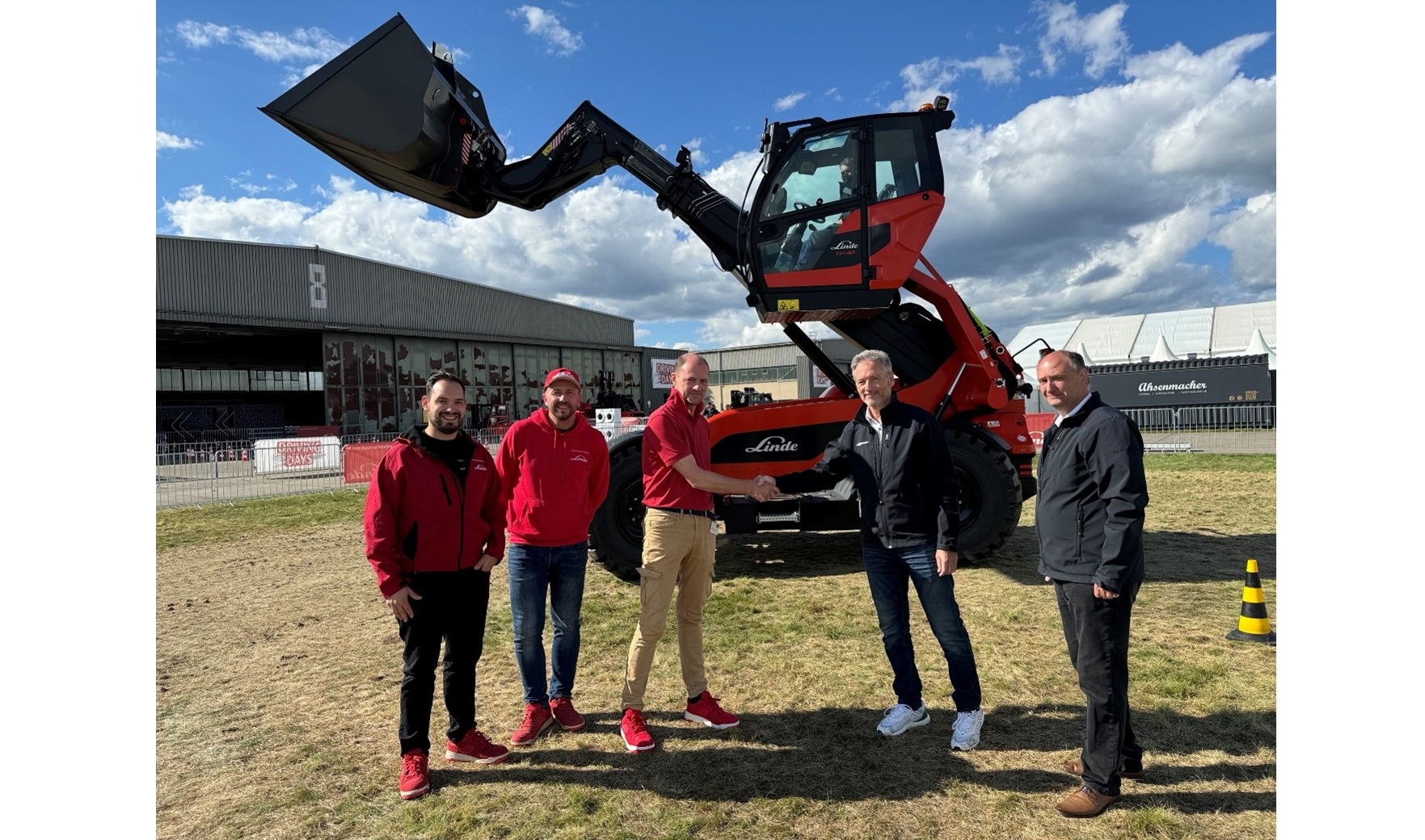 Company representatives from LINDE and SENNEBOGEN jointly present the new telehandlers in the characteristic colour scheme.