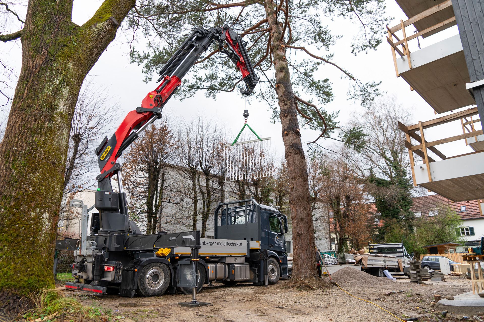 Balcony railing sections must be safely hoisted over the multi-unit building — a task the PK 580 TEC masters effortlessly. 