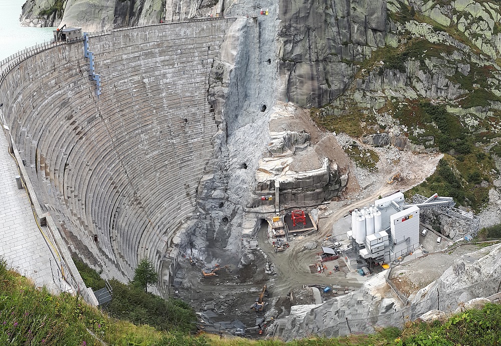 Short distances: the new double-curved arch structure is being built directly in front of the existing dam. The different recipes from the SBM mixing systems can be processed immediately using a crane bucket. 
