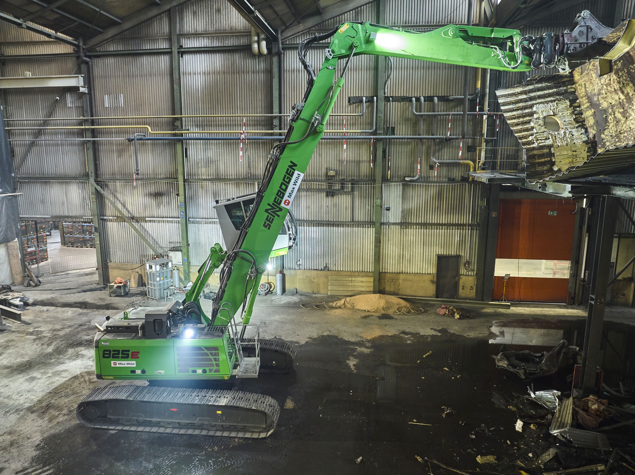 Long reach of the boom enables selective dismantling even under the hall roof.