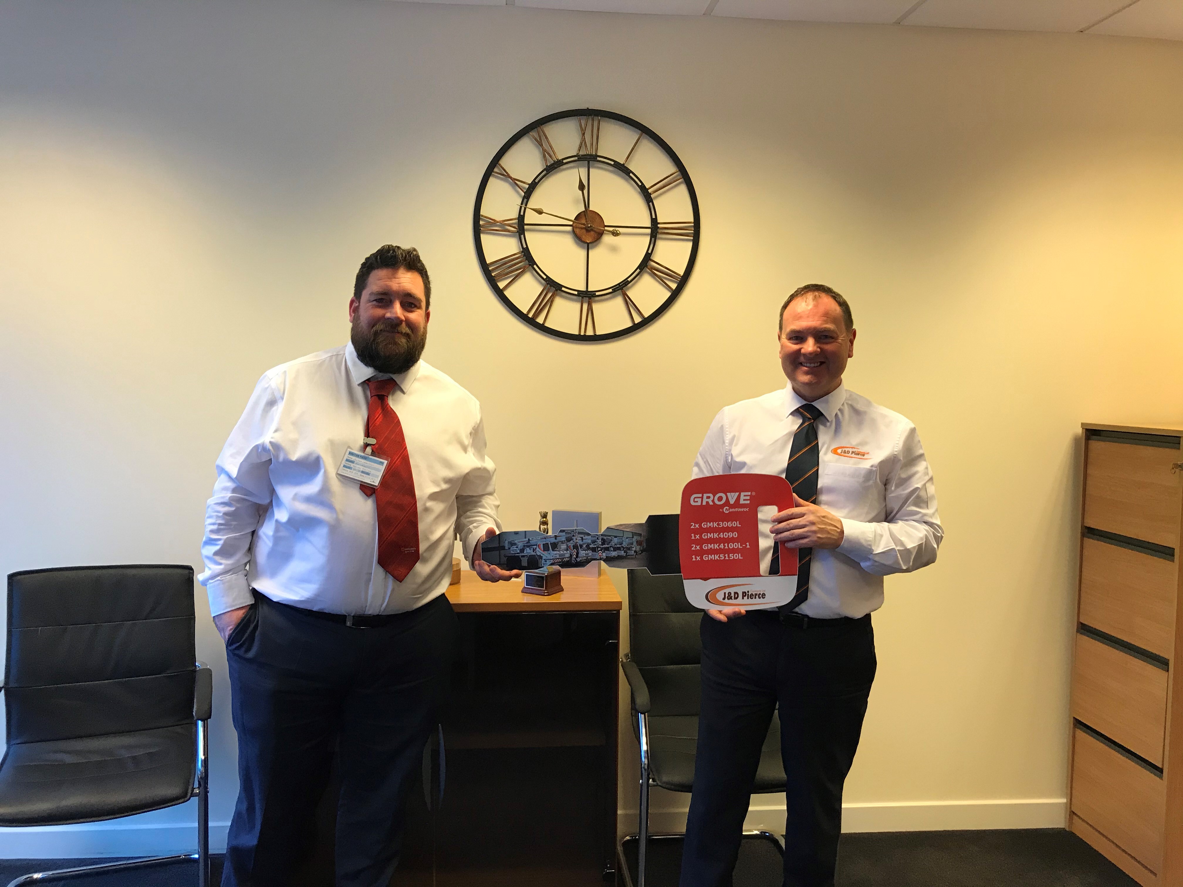 James Leishman, sales manager at Manitowoc UK, presents Derek Pierce, managing director of J & D Pierce, with a ceremonial key representing the handover of the cranes.