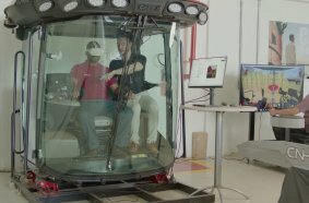 A CNH employee in a cab operation simulator undergoing interactive training via a virtual reality headset