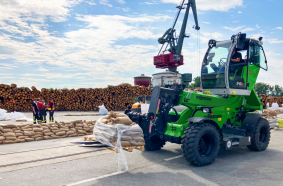 A Sennebogen telehandler transports sandbags on the harbor site.