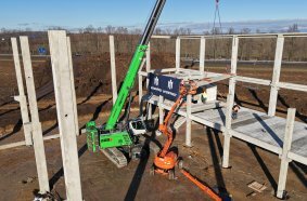 Assembly of the prefabricated concrete structure in the AVENTIN Dyje Industrial Park – the SENNEBOGEN 683 E performs key lifting and positioning tasks. 