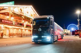 The Mercedes-Benz eActros 600, adorned in a distinctive dirndl and lederhosen-themed wrap, delivers supplies to the Schwabenbräu festival tent at the Cannstatter Volksfest.
