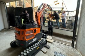 Develon Mini-Excavator Used to Install Panes of Glass in Home