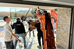 Develon Mini-Excavator Used to Install Panes of Glass in Home