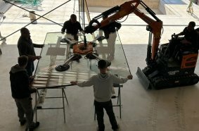 Develon Mini-Excavator Used to Install Panes of Glass in Home