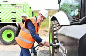 West Midlands Mayor Andy Street refuels a JCB backhoe loader with hydrogen from the new JCB refueller during a visit to JCB