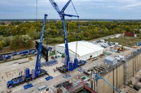 After being lifted by four mobile cranes, the...