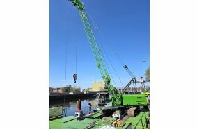 The new SENNEBOGEN 630 E operated by WSA Spree-Havel is securely mounted on a pontoon and deployed as a floating duty cycle crane for inland waterway operations.
