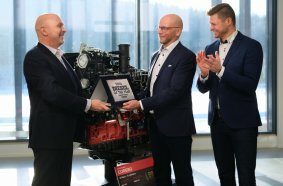 Powertrain International Editor-in-Chief Fabio Butturi (left) presents the Diesel Engine of the Year 2026 award to AGCO Power Vice President Juha Tervala. Next to them, AGCO Power Project Manager for Engineering Juha-Pekka Asikainen applauds. In the background: the CORE80 engine.