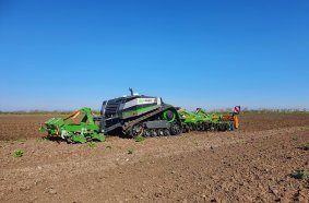 The tracked AgXeed AgBot with 3 m AMAZONE Cenio mounted cultivator and front-mounted knife roller