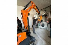 Develon Mini-Excavator Used to Install Panes of Glass in Home
