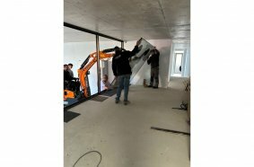 Develon Mini-Excavator Used to Install Panes of Glass in Home