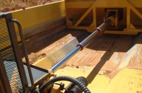 A single hydraulic cylinder operates both the ejector blade and the rear tailgate mechanism.