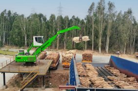Efficient timber handling: The stationary 821 E Electro proves its high handling capacity when feeding the conveyor belt with logs.