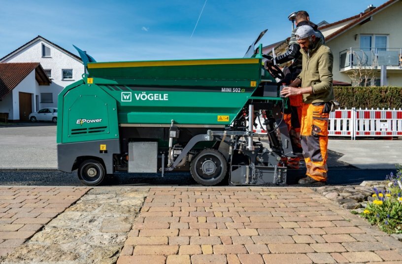 Low noise level and zero local emissions: the drive, the material conveying systems and the screed heating of the MINI 502e wheeled paver are exclusively electrically-powered.Low noise level and zero local emissions: the drive, the material conveying systems and the screed heating of the MINI 502e wheeled paver are exclusively electrically-powered.<br>IMAGE SOURCE: WIRTGEN GROUP