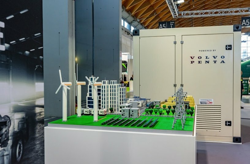 TecnoGen’s BESS for heavy-duty vehicle charging sitting next to a model showcasing BESS potential in different parts of society.<br>IMAGE SOURCE: SE10 PR; Volvo Penta