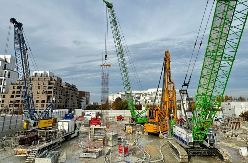 Drei SENNEBOGEN-Krane und Seilbagger auf der Baustelle Les Caboeufs in Gennevilliers: Der 6130HD mit Schlitzwandgreifer im Tandem mit einer Hydrofäse, der 6140HD beim Schwerlasthub und der Raupenkran 3300 beim Verheben von Bewehrungskörben.<br>BILDQUELLE: SENNEBOGEN Maschinenfabrik GmbH