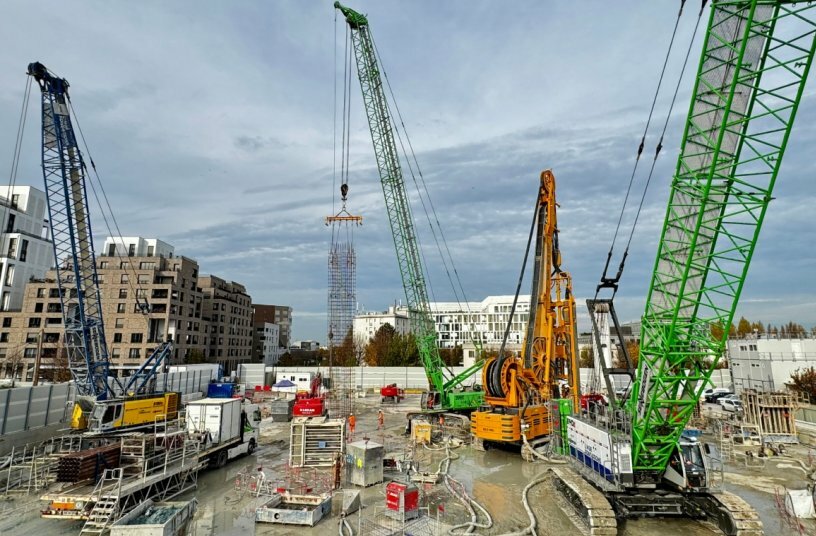 Three SENNEBOGEN cranes and duty cycle cranes on the Les Caboeufs construction site in Gennevilliers: The 6130HD with diaphragm wall grab working in tandem with a hydro cutter, the 6140HD performing a heavy-duty lift, and the 3300 crawler crane lifting reinforcement cages.<br>IMAGE SOURCE: SENNEBOGEN Maschinenfabrik GmbH