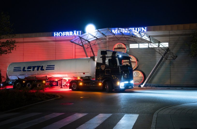 The Mercedes-Benz eActros 600, adorned in a distinctive dirndl and lederhosen-themed wrap, delivers supplies to the Oktoberfest.<br>IMAGE SOURCE: Daimler Truck AG