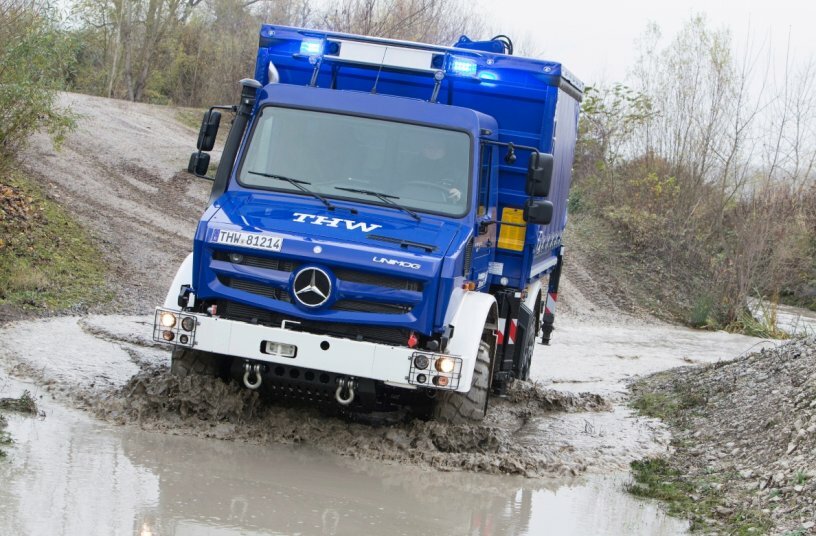 Unimog U 5023 for THW for flood protection with Atlas loading crane AT96.2 in use<br>IMAGE SOURCE: Daimler Truck AG