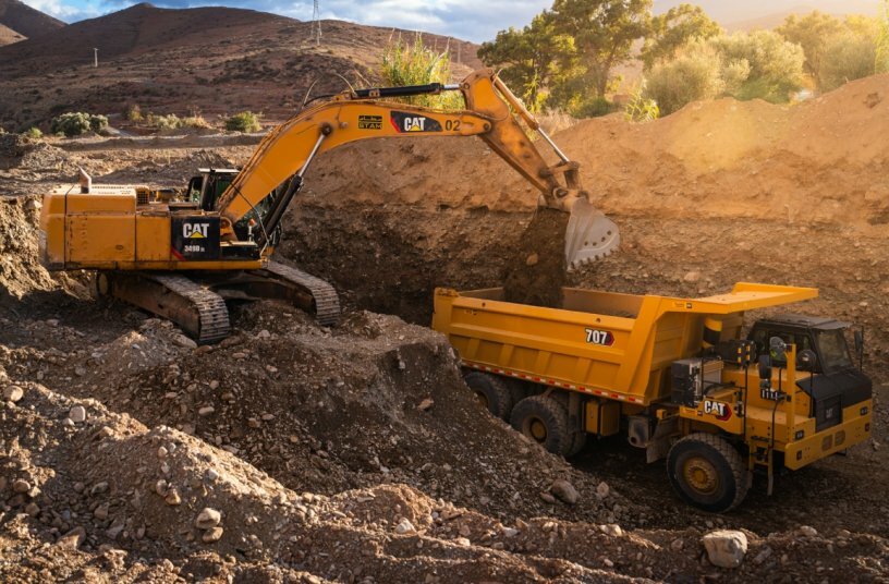 Cat® 707 wide body truck with excavator<br>IMAGE SOURCE: Caterpillar